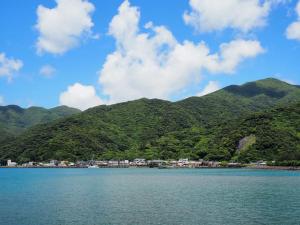 a large body of water with mountains in the background at うみうたう in Yuwan