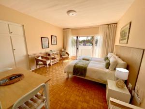 a bedroom with a bed and a desk and a window at Loewenhoff Seaview Suite 2 in Swakopmund
