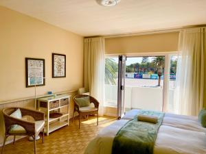a bedroom with a bed and a desk and a window at Loewenhoff Seaview Suite 2 in Swakopmund