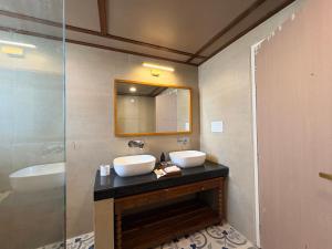 a bathroom with two sinks and a mirror at RajVana, Ranthambore in Khilchipur