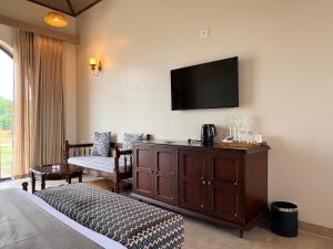 a hotel room with a bed and a tv on the wall at RajVana, Ranthambore in Khilchipur +17 photos