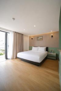 a bedroom with a large white bed and a large window at Y Hotel Lý Hồng Thanh in Can Tho