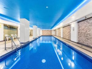 a large swimming pool with a blue ceiling at Elevated CBD Retreat - Views & Pool & Sauna! in Melbourne