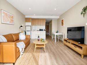 a living room with a couch and a table at Elevated CBD Retreat - Views & Pool & Sauna! in Melbourne