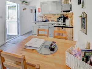 a kitchen with a wooden table and a kitchen with white cabinets at Hoy Hideaway in Whitwell