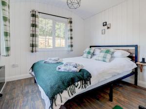 a bedroom with a bed with a blanket on it at Hoy Hideaway in Whitwell