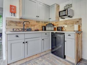 a kitchen with white cabinets and a dishwasher at Hoy Hideaway in Whitwell +11 photos
