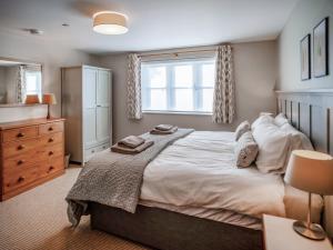 a bedroom with a large bed and a window at Pandy Newydd in Trefriw