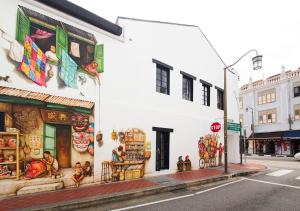 a white building with paintings on it on a street at Heritage Collection on Chinatown - Mobile App Check-In in Singapore