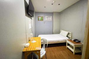 a small hospital room with a bed and a desk at Hotel Uno in Davao City