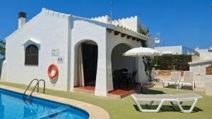 a villa with a swimming pool and a house at Nachetes 1 in Cala Blanca
