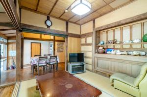 a living room with a table and a tv at Kume Guest House in Kumejima +38 photos
