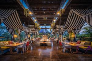 a restaurant with tables and chairs on a deck at Royal Arkara Villas by Arkamara in Ubud