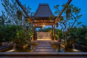 a gazebo in a garden at night at Royal Arkara Villas by Arkamara in Ubud