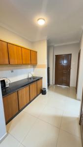 an empty kitchen with a sink and wooden cabinets at Damai Laut Serene Stay Studio Lumut in Lumut