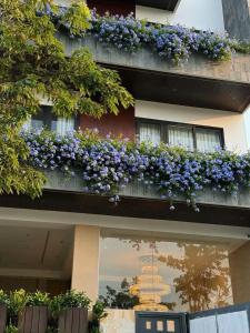 a building with purple flowers on a balcony at Verdant Apartment & Hotel in Dong Hoi