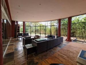 a living room with tables and chairs and windows at Hill Cottage in Moshi +10 photos