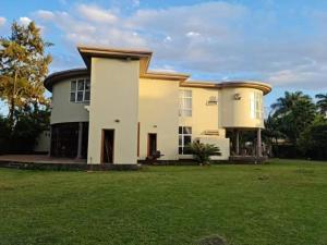 a large house with a green yard at Hill Cottage in Moshi