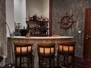 a bar with four bar stools in a room at Hill Cottage in Moshi