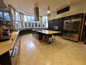 a large kitchen with a table and a refrigerator at Hill Cottage in Moshi