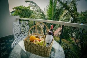 a basket of fruit and a bottle of wine on a table at The Baga Pescador in Baga