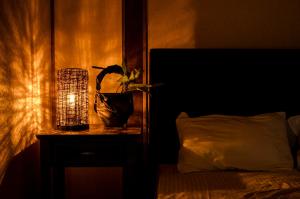a bedroom with a table with a plant and a lamp at Kume Guest House in Kumejima