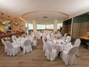 a banquet hall with white tables and white chairs at Fora Hotel Hannover by Mercure in Hannover