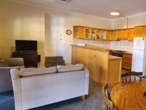a living room with a couch and a kitchen at Bungaree Station in Clare