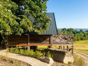 a wooden building with a green roof on a field at Sumadijski ranc-Brvnara in Brestovac