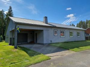 a gray building with a garage with a driveway at Villa Edda in Vidsel