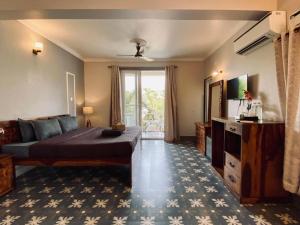 a bedroom with a bed and a large window at The Baga Pescador in Baga