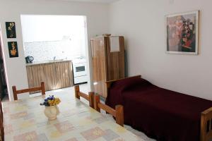 a bedroom with a bed and a table and a kitchen at Departamentos San Jorge in Santa Rosa
