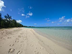 a beach with footprints in the sand and the ocean at Isola Riambel in Riambel