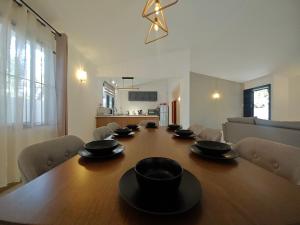 a long wooden table with black bowls on it at Isola Riambel in Riambel