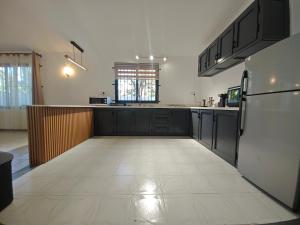 a kitchen with black cabinets and a white tile floor at Isola Riambel in Riambel +7 photos