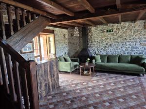 a living room with green couches and a table at El Conventu del Asturcon in Lago +57 photos