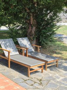two wooden benches sitting on top of a sidewalk at El Conventu del Asturcon in Lago