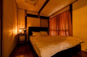 a bedroom with a large bed with a window at Kume Guest House in Kumejima