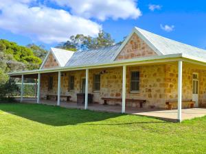 an old stone house with a porch and grass at Bungaree Station in Clare