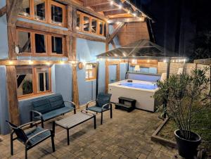 a patio with a tub and chairs and a house at Le Chalet Cozy & Spa in Wildersbach