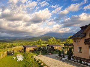 a house with a yard with a mountain in the background at Cabanuta Din Deal in Racoviţa