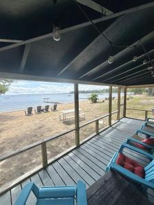 a porch with blue chairs and a beach at FRIENDLY INN LIMIT 5 cottage in North Sebago