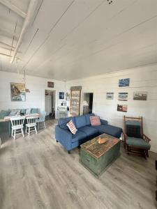 a living room with a blue couch and a table at FRIENDLY INN LIMIT 5 cottage in North Sebago