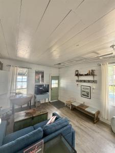 a living room with two blue couches and a television at FRIENDLY INN LIMIT 5 cottage in North Sebago +7 photos