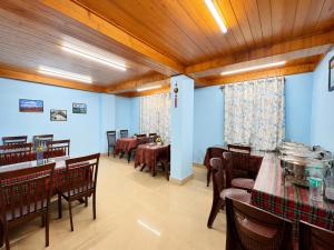 a dining room with tables and chairs and blue walls at Hotel Pinecrest Inn Darjeeling With Mountain View Room And Parking - Restaurant Facility in Darjeeling