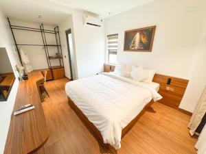 a bedroom with a large bed with white sheets at Verdant Apartment & Hotel in Dong Hoi