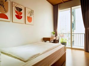 a bedroom with a bed and a large window at XÔI Sakamoto 2 Suites Kim Ma in Hanoi