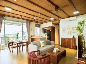 a living room with a couch and a table at XÔI Sakamoto 2 Suites Kim Ma in Hanoi