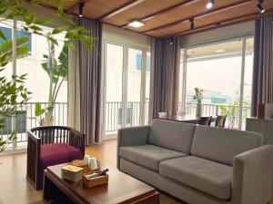 a living room with a couch and a table at XÔI Sakamoto 2 Suites Kim Ma in Hanoi