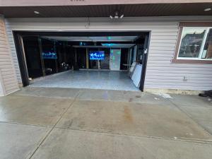 a building with a garage with a door open at Modern Family Home with guest heat garage, Pet-Friendly!- NO BASEMENT in Edmonton